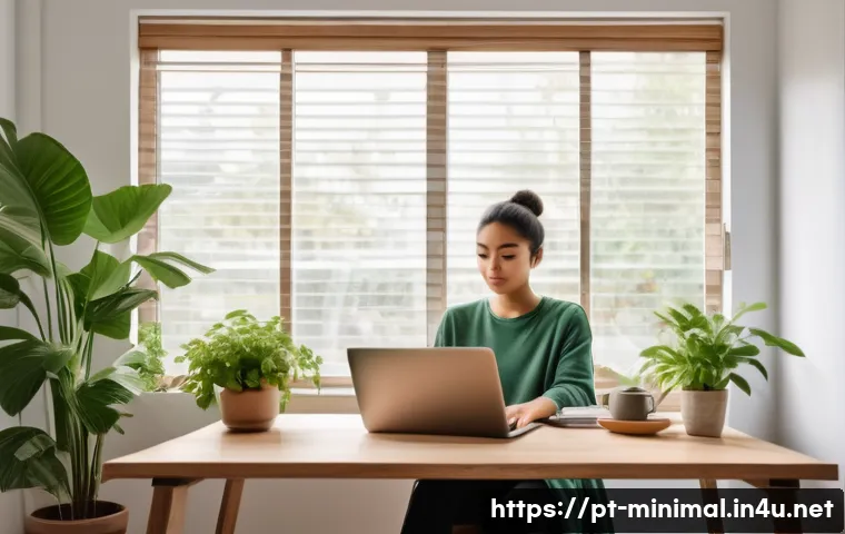 미니멀라이프 디지털 미니멀리즘 - A serene home office scene showing a young professional seated at a minimalist wooden desk, using a ...
